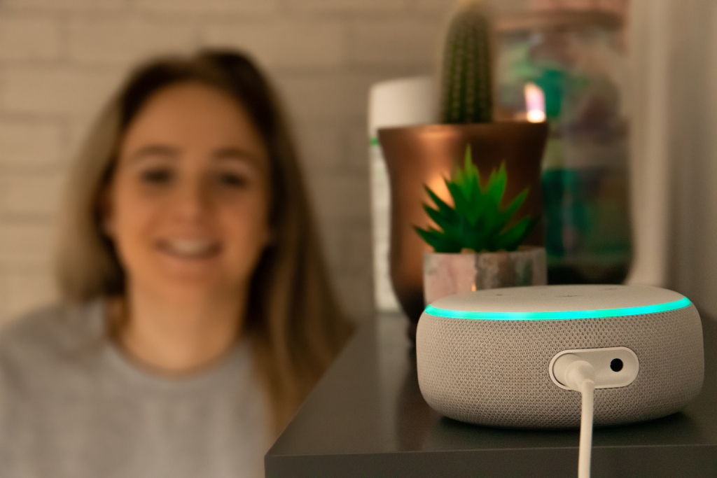 Teenage girl talking to an Amazon Alexa Echo Dot 